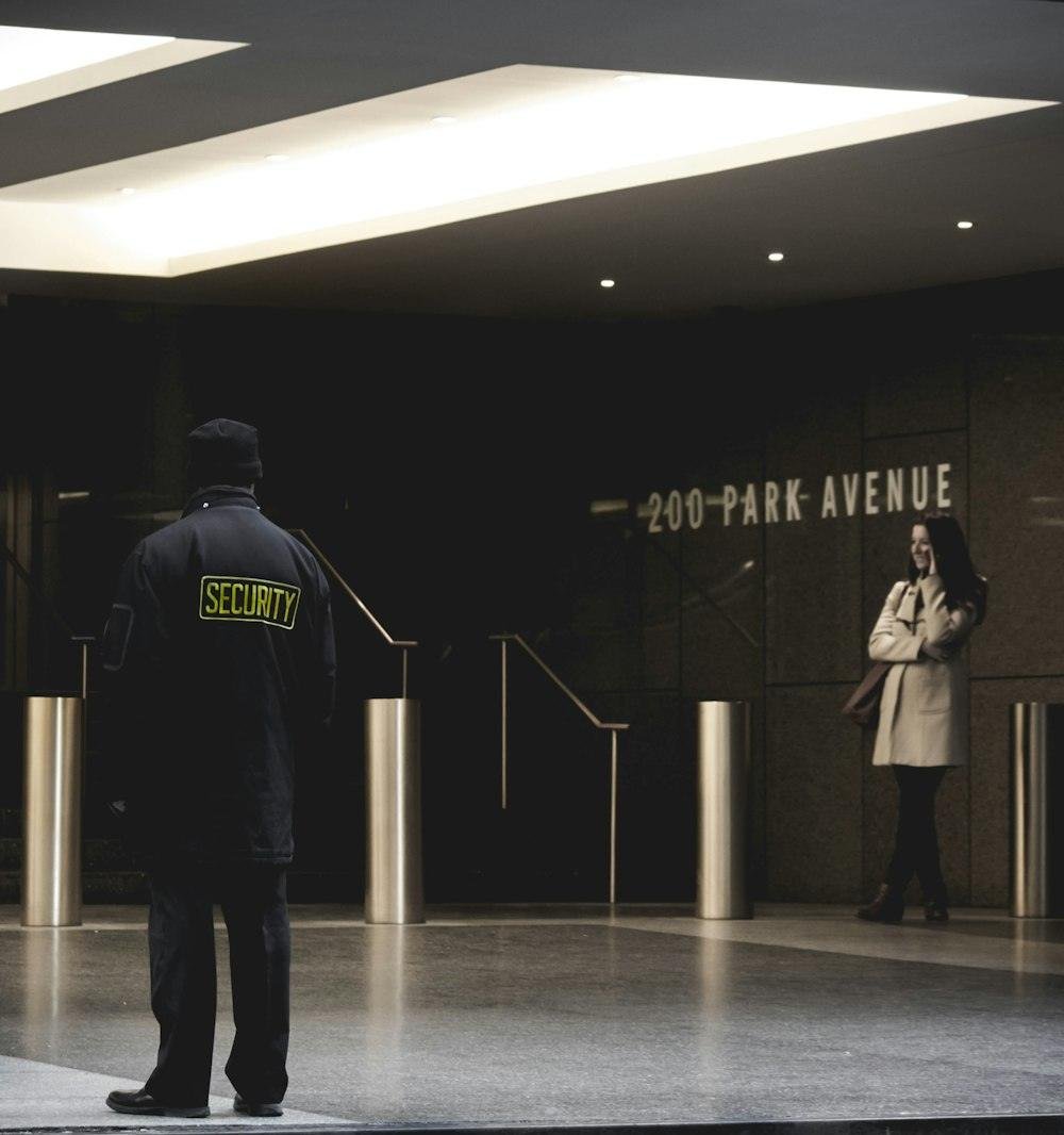 A uniformed security guard watching over a building lobby