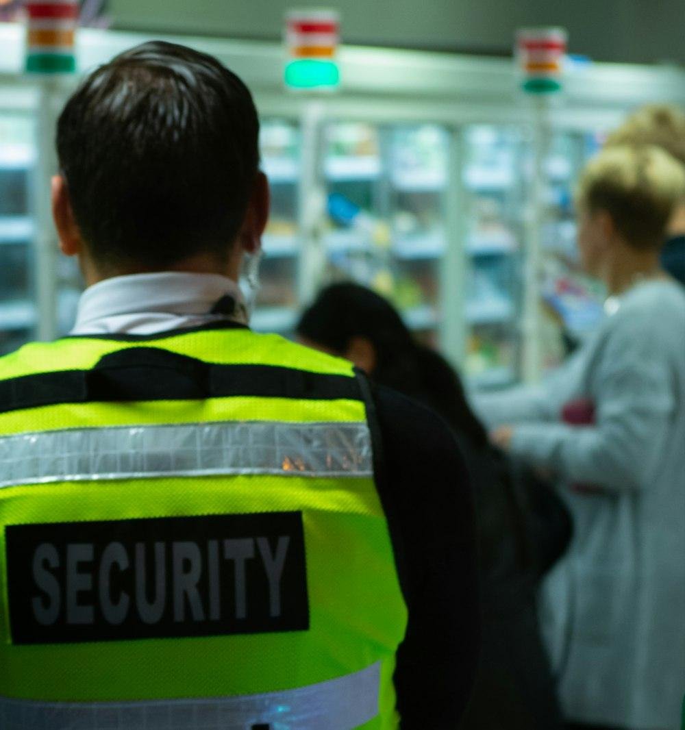 A security guard in a high-visibility vest inside a busy store