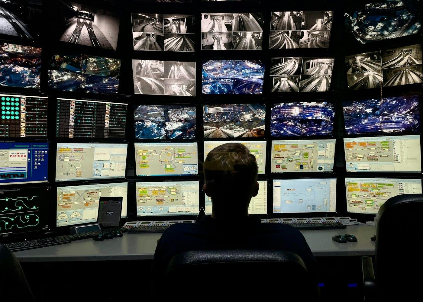 A security operator watching a wall of monitoring screens
